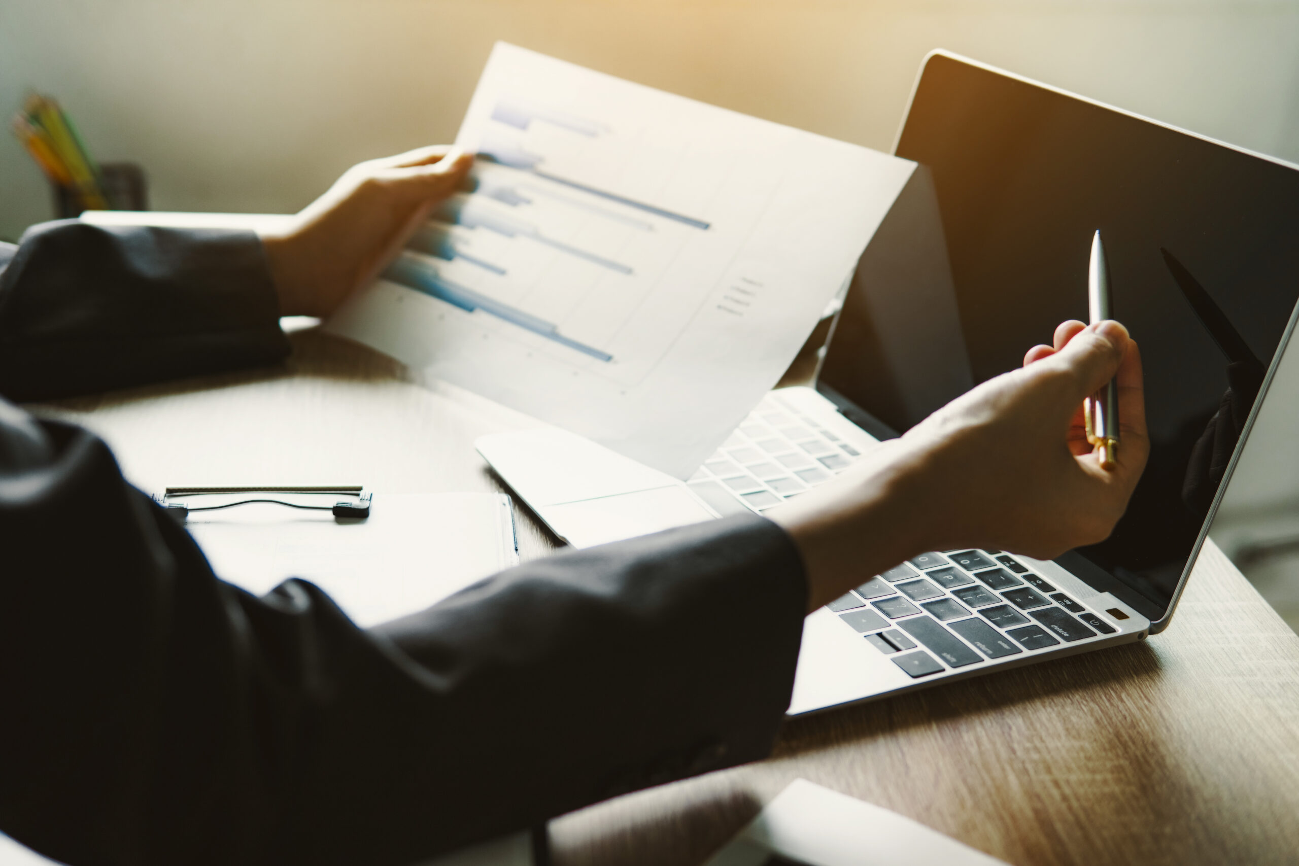 Business financial manager holding finance graph document for analyzing monthly expense of company.